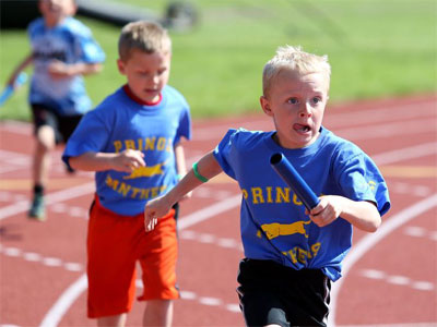 kids running baton race at school sports day